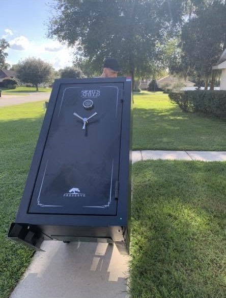 Black safe with clock face displayed on front lawn during daytime